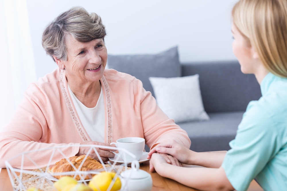 Resident and caretaker enjoying a cup of coffee